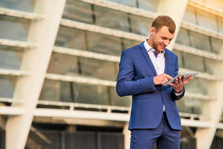 Businessman using tablet and smiling. Cheerful man in a suit. - Stock ...