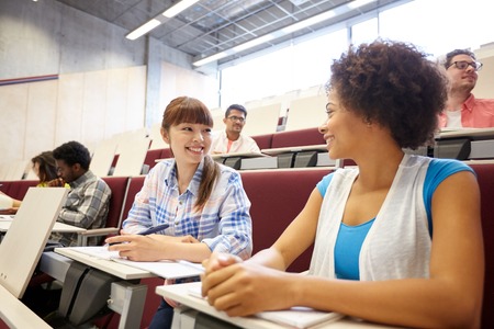 education, high school, university, learning and people concept - group of international students talking on lecture