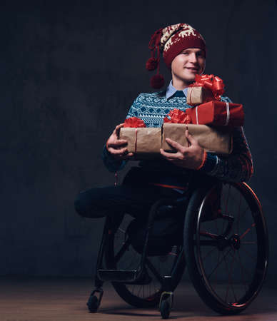 A man in wheelchair with Christmas gifts.