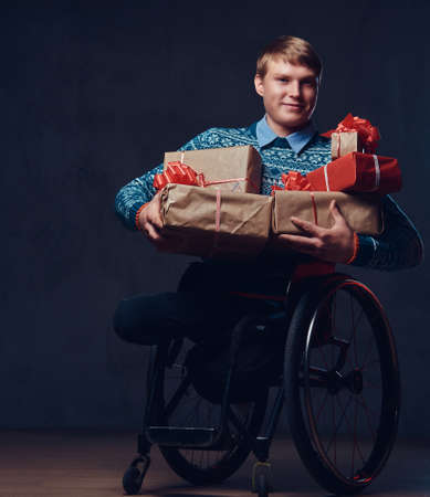 A man in wheelchair with Christmas gifts.