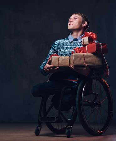 A man in wheelchair with Christmas gifts.