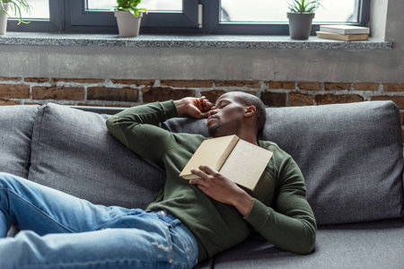 portrait of young african american man with book sleeping on sofa at home |  Stock Images Page | Everypixel