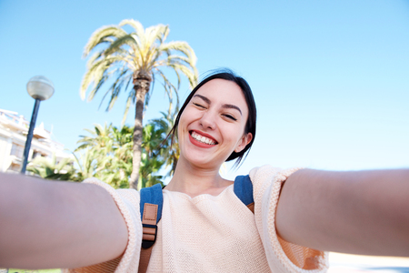 Selfie portrait of playful young woman outside winking - Stock Image ...