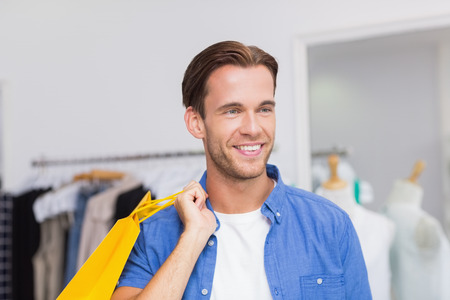 A smiling man with shopping bags at the clothing store - Stock Image ...