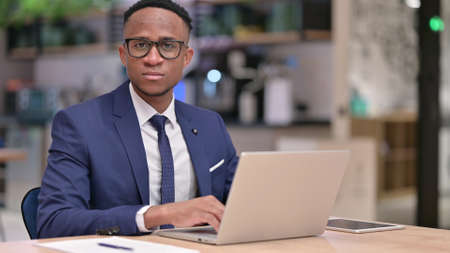 Serious Young African Businessman with Laptop Looking at Camera - Stock ...