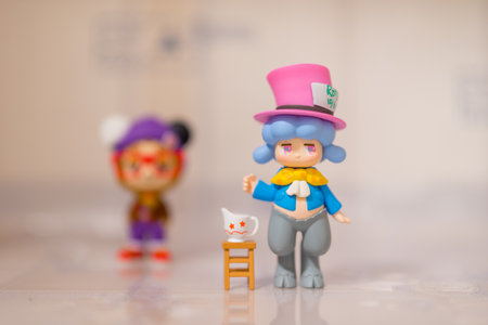 Colorful toy figurines with a small cat on a chair. Studio shot.の写真素材