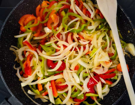 top view of a frying pan with vegetables cookingの写真素材