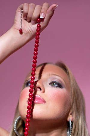 Blond girl and red pearlsの写真素材