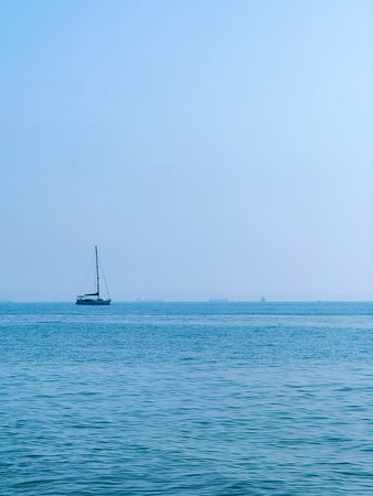 Picturesque beach, waves crashing on the sandy shore. Sea waves beat against the rocks. Umbrellas, tourist boats.の写真素材