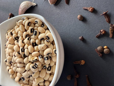 Black-eyed peas in white bowl on a black surface. Healthy, wholesome, plant-based food.