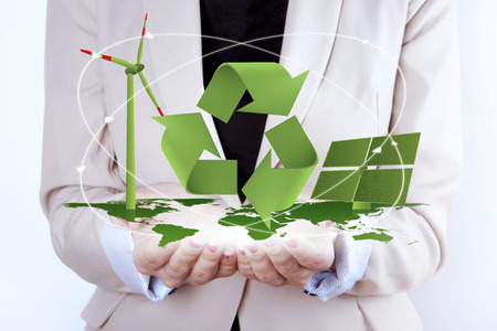 Green Energy Digital symbol of Solar Panel Wind Turbine and ECO sign on map of earth. All together in woman's hands. Woman is suggesting let us think GREEN and take care of the energy. Digitally generated elements are in green color.の写真素材