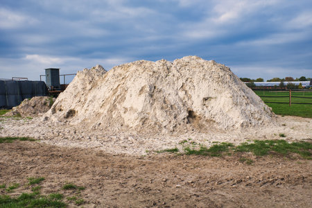 Large pile of sand in the field on a background of blue skyの写真素材