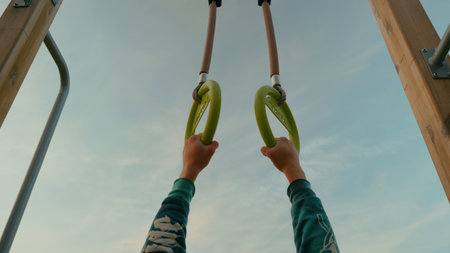 Hands of a young woman doing exercises on an outdoor sports groundの写真素材