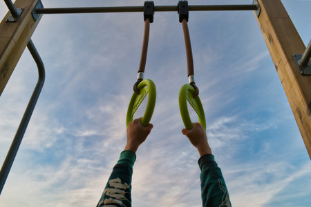 Close-up of child's hands hanging on a rope.の写真素材