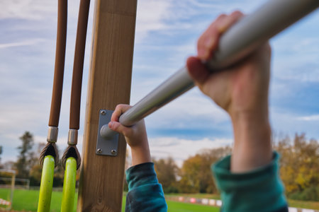 Close-up of a child's hand holding a sports horizontal bar.の写真素材