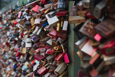 Many colorful padlocks are attached to a fence in a public space, symbolizing love and commitment.の写真素材