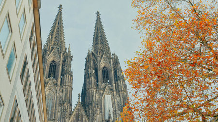 Colorful leaves surround towering Gothic spires, showing the beauty in autumn's gentle light.の写真素材