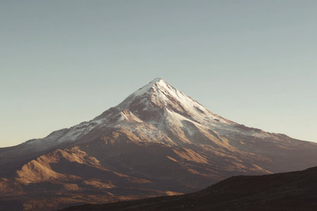 Golden hour light casts a warm glow over the majestic mountain peak, enhancing its beauty at dusk.の素材