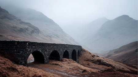 A stone bridge crosses a misty valley surrounded by mountains. The scene shows nature waking up in the morning.の素材