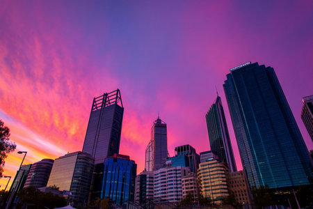 City buildings show their outlines in the bright colors of a sunset sky. This scene captures the end of the day.の素材