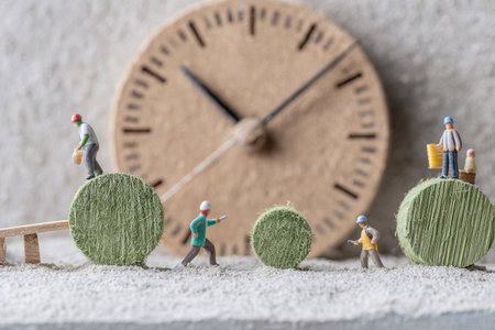 Small figures are busy with work on round objects while a clock shows the time in the background.の素材