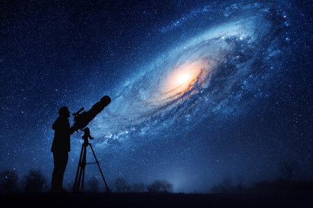 A person looks through a telescope, focusing on a bright galaxy in the night sky. Stars shine around the scene.の素材