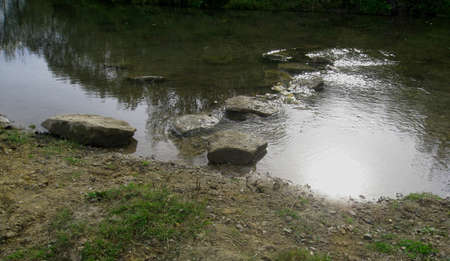Rocks in the water and the reflection of the sun's disk. View from above.の写真素材