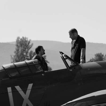 Big and small man speaking in plane open cockpit in black and whiteのeditorial素材