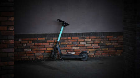 City electric scooter leaning against a brick wall in a disgusting alley, Bratislava, Slovakiaの写真素材