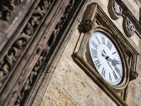 A clock with Roman numerals on the side stone wall of the Prague Astronomical Clock, Czech Republicの写真素材