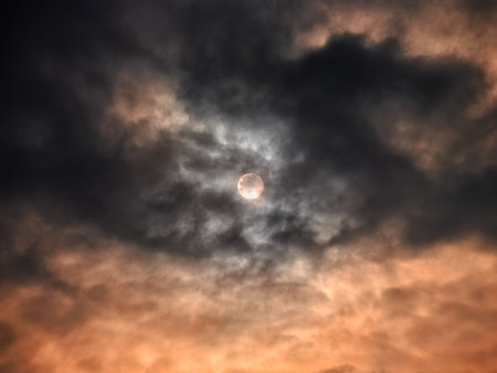 Full moon behind dramatic clouds