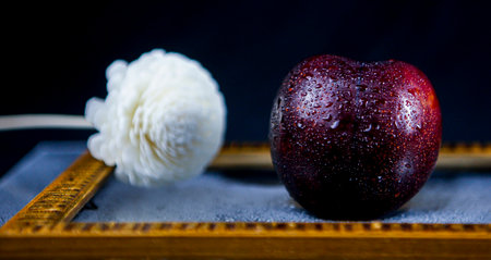 Red apple and white cotton ball on a wooden tray. Selective focus.の写真素材