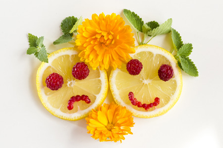 Joyful and sad lemon with mint leaves on a white .の写真素材