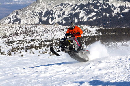 Athlete on a snowmobile moving in the winter forest in the mountains of the Southern Urals.の写真素材
