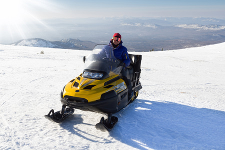 Athlete on a snowmobile moving  in the mountains of the Southern Urals.