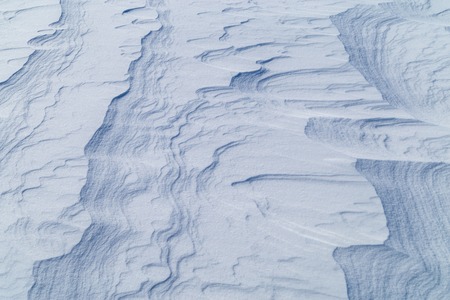 Icy texture of snow after a blizzard on a sunny morning.の写真素材