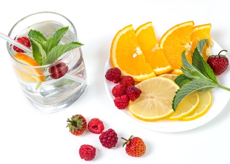 Berry lemonade of fresh berries and citrus fruits on a white background.