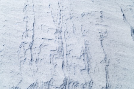 Icy texture of snow after a blizzard on a sunny morning.の写真素材
