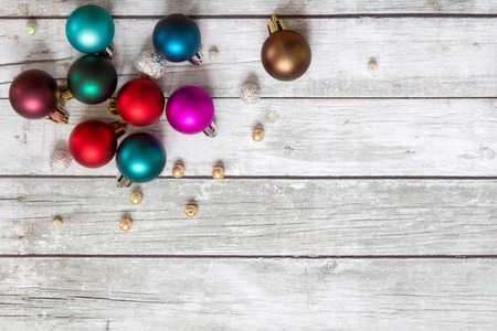 Multicolored Christmas balls and pearls on a wooden background. Space for text.の写真素材