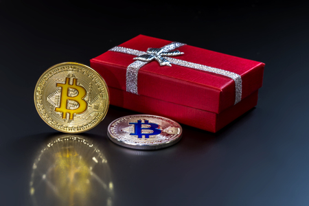 The physical version of Bitcoin (new virtual money) against the background of urban buildings. A...