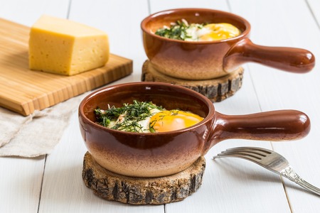 Eggs in a cocotte, baked with onions, dill and cheese.の写真素材