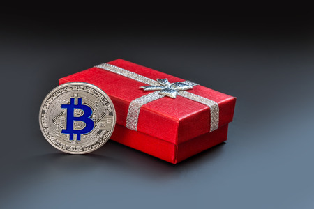 The physical version of Bitcoin (new virtual money) against the background of urban buildings. A conceptual image for investors in encryption and blockchain technology.の写真素材