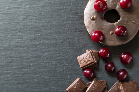 Cherries and broken chocolate on a dark background.の写真素材