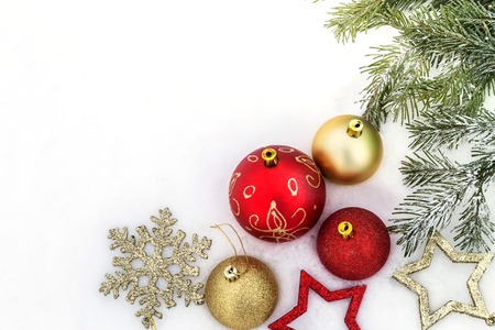 Christmas decorations lie on the snow near the Christmas tree.の写真素材