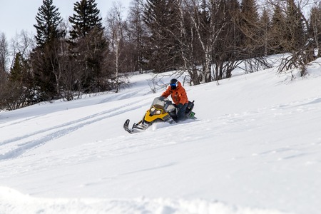 Athlete on a snowmobile moving in the winter forest in the mountains of the Southern Urals.の写真素材