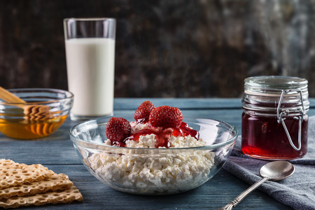 Cottage cheese with jam and strawberry on a wooden table.の写真素材