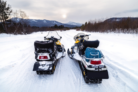 Two snowmobiles on the road in the mountains of the Urals.の写真素材
