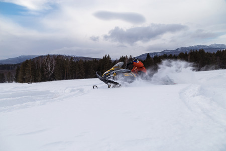 Athlete on a snowmobile moving in the winter forest in the mountains of the Southern Urals.の写真素材