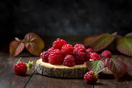 Fresh raspberry with leaves on wooden backgroundの写真素材