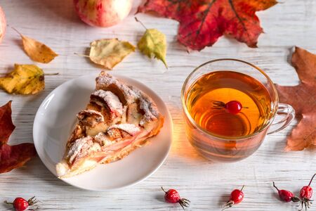 Tea and pie with apples on a light table.の写真素材